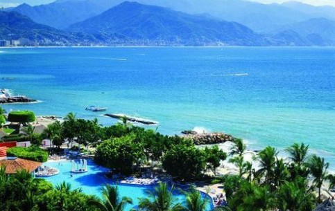 Puerto Vallarta is a cozy resort town with stone-paved streets, colonial tiled-roof houses, modern hotels buried in verdure, many miles of golden beachs and picturesque embankment